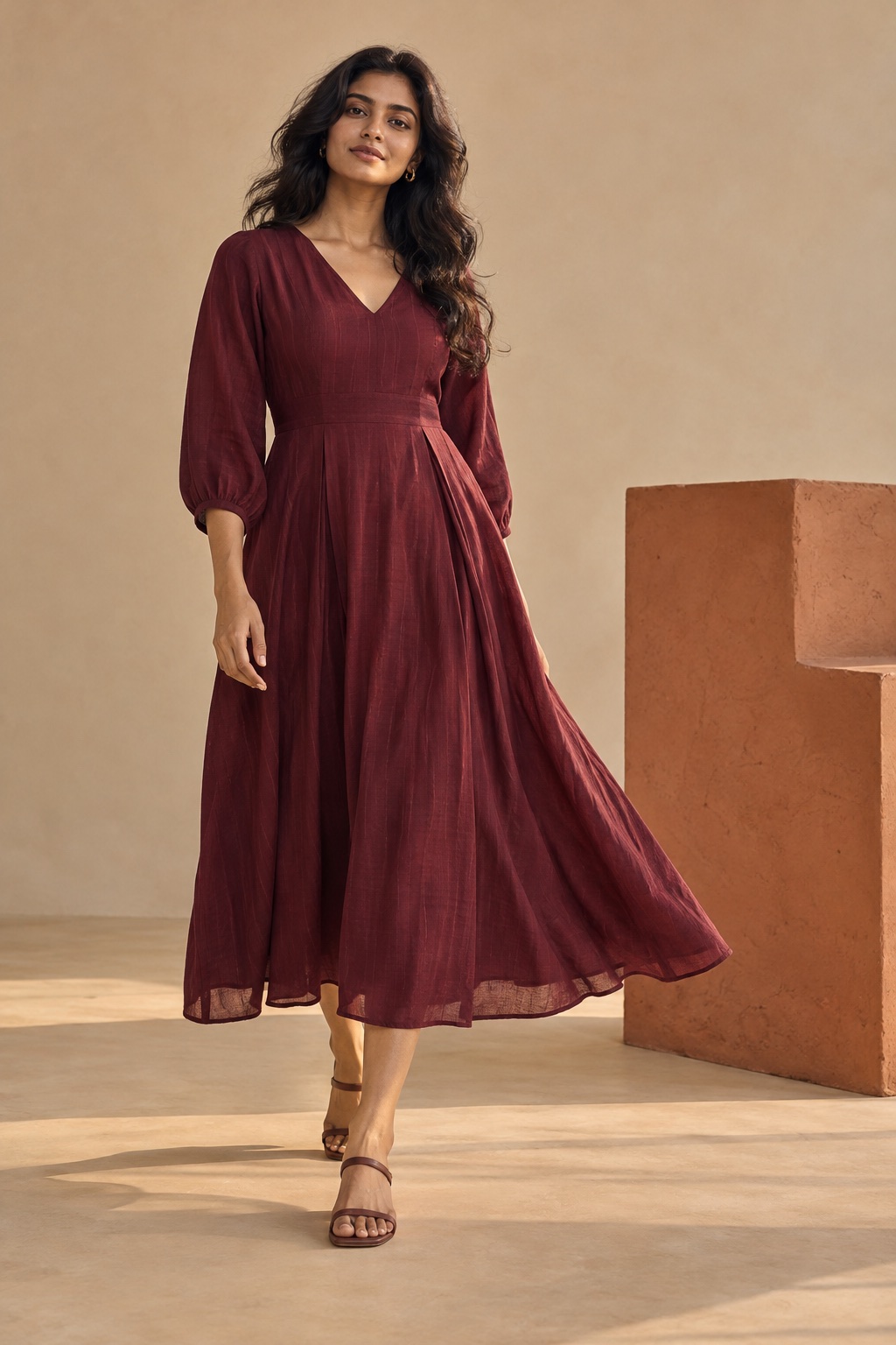 Woman wearing a flowing deep-maroon contemporary dress